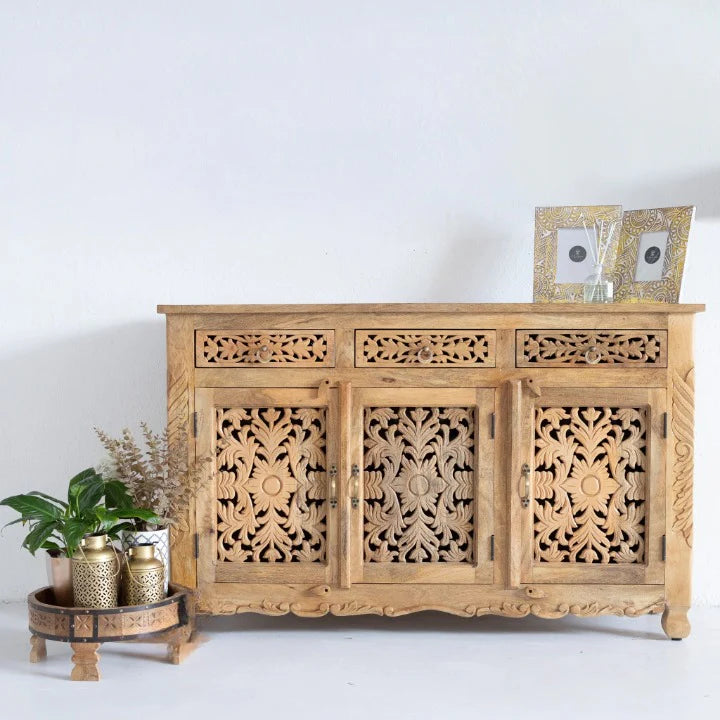 hand carved sideboard, mango wood sideboard, natural finish sideboard, floral carved sideboard, openwork sideboard, 3 door sideboard, 3 drawer sideboard, buffet sideboard, indian carved furniture, storage sideboard, dining room buffet, living room sideboard, entryway sideboard, statement sideboard, medium sideboard, handmade sideboard, artisan made sideboard, premium wood buffet, quality wood furniture, durable sideboard, sturdy buffet, timeless sideboard, elegant buffet, heirloom buffet, rustic sideboard,