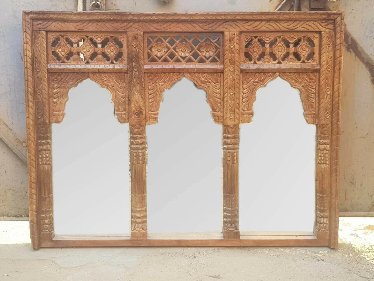 Carved wooden panel with intricate patterns on a plain background