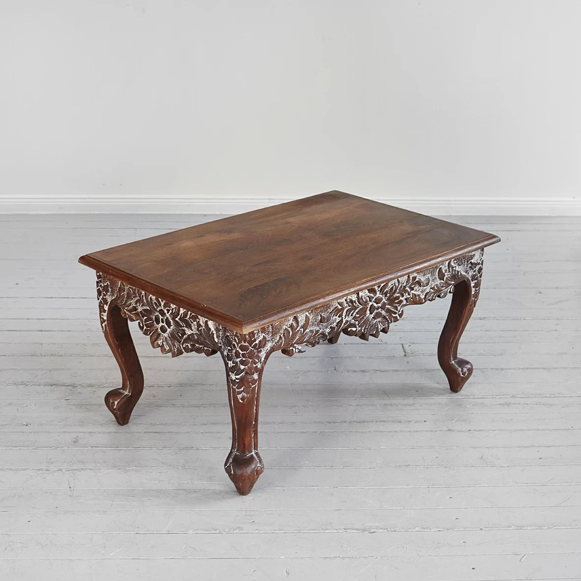 Hand‑carved mango wood coffee table with cabriole legs, 91 × 60 × 47 cm.