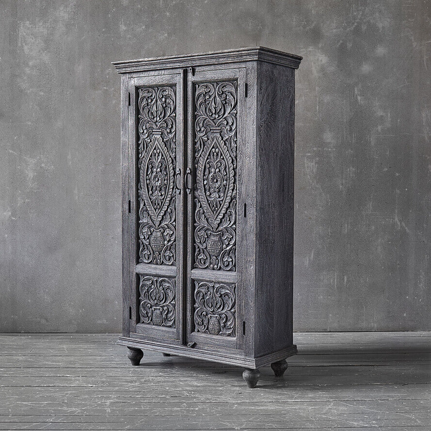 Tall carved wooden storage cabinet with ball feet and ornamental detailing.