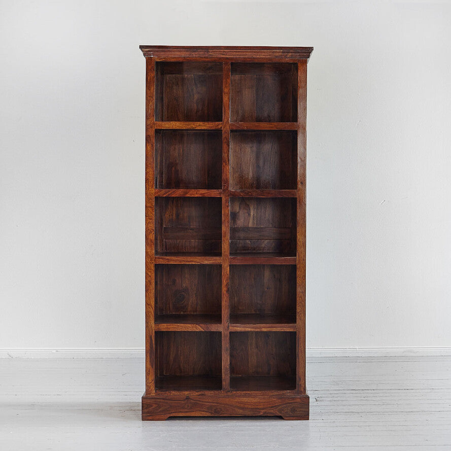 Wooden bookshelf with multiple shelves against a white wall.