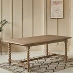 Wooden dining table in a room with beige paneling and a decorative rug.