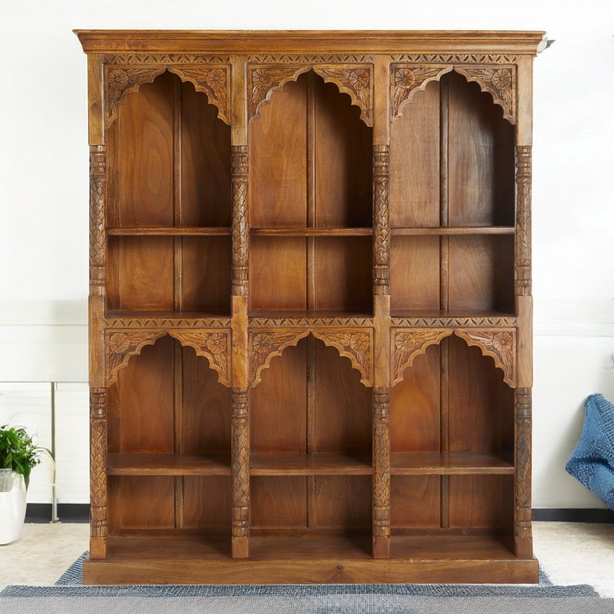 Modern bookshelf in a stylish living room, with a tall bookcase and bookrack on the side.
