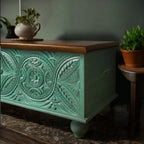 Vibrant teal decorative storage trunk styled as a rustic centerpiece with artisan detailing.
