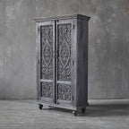 Tall carved wooden storage cabinet with ball feet and ornamental detailing.

