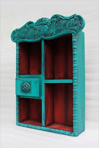 Artisan wood carving designs on cobalt blue shelf cabinet showing floral motifs