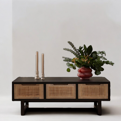 Rattan coffee table with a round top, paired with a cozy sofa and neutral decor.
