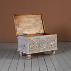 Compact coffee table chest with floral carved panel, grey finish, and natural wood top.

