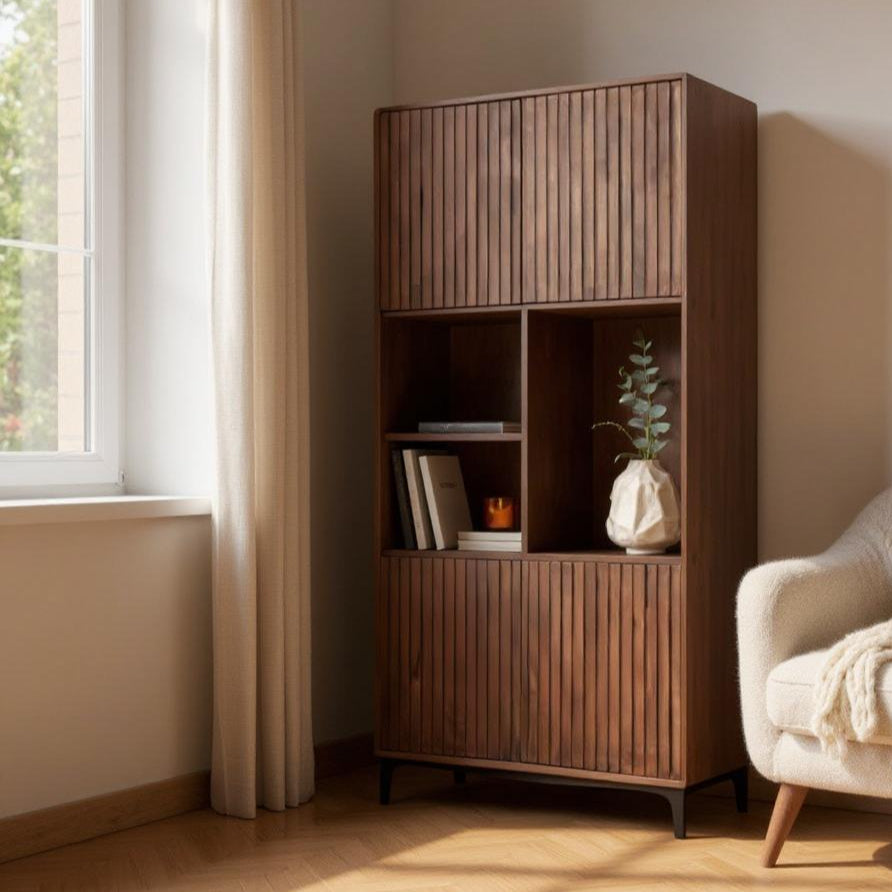 Wooden bookshelf in a room with a window and a beige armchair.