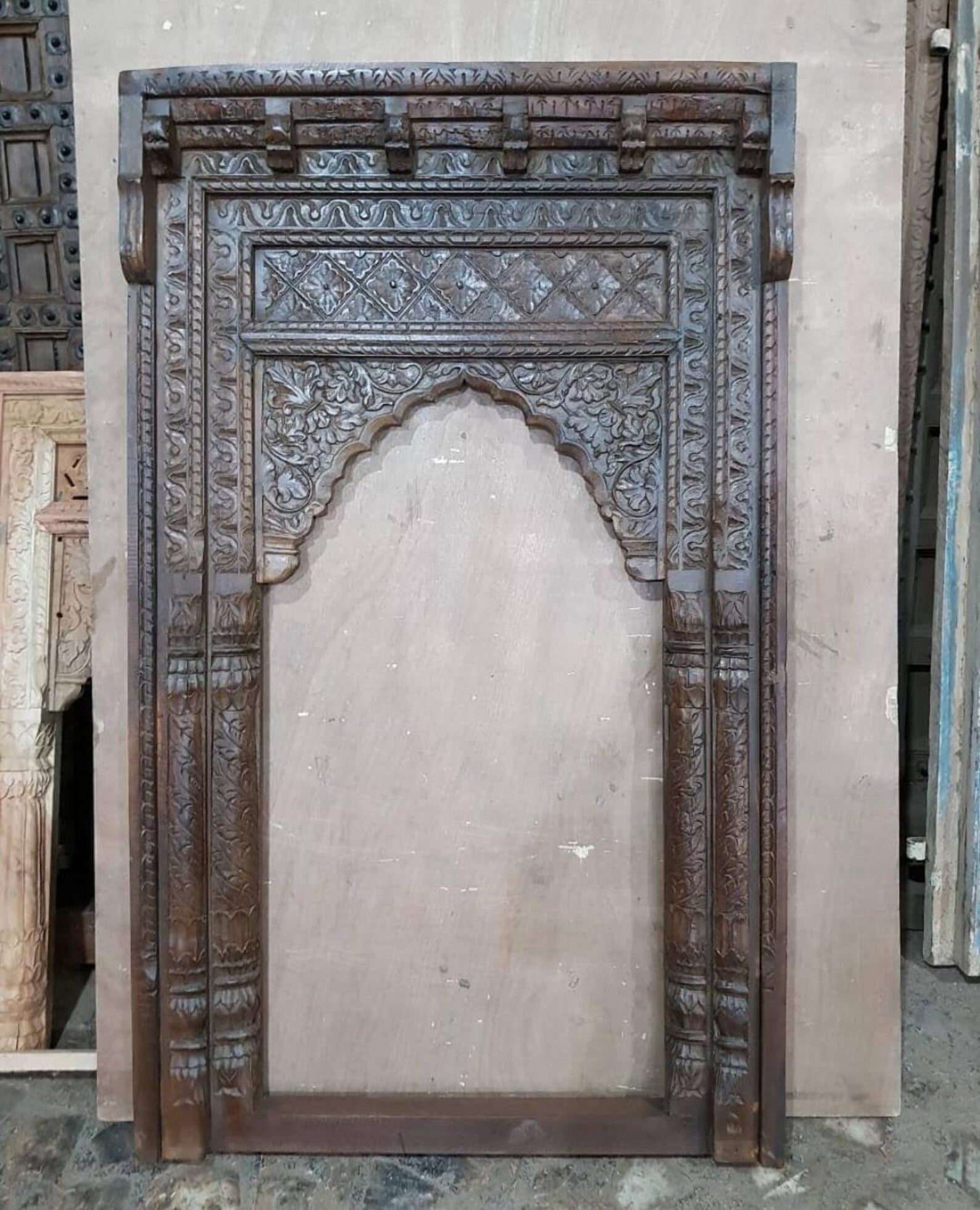 Hand‑carved mango wood full‑length mirror with Mughal Mehrab arch, triple pilasters, and distressed brown finish, 210 × 110 × 15 cm.

