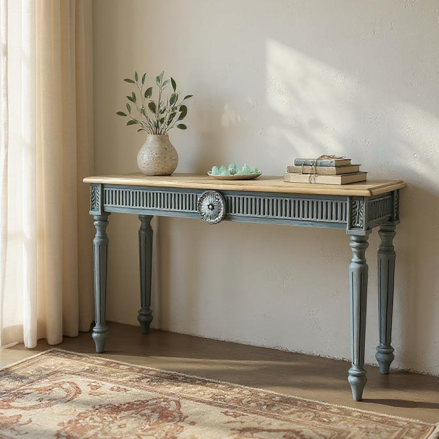 Console table with decorative items in a room with sunlight streaming through a window.